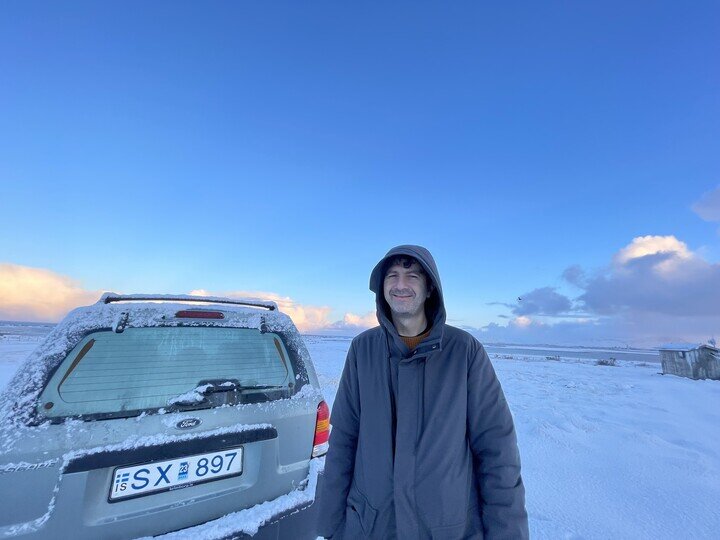 Kurt Uenala on frozen landscape next to car
